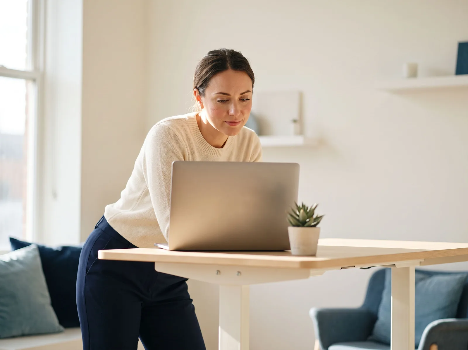 A bookkeeper working on a laptop at a standing desk in a bright studio